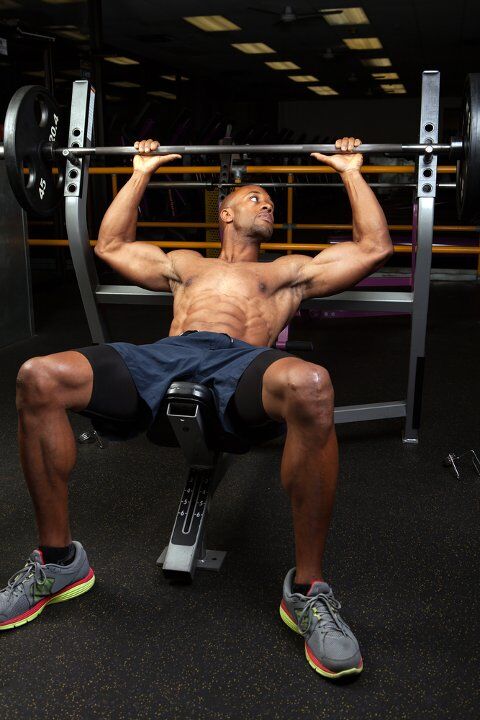 Man performing incline bench press exercise