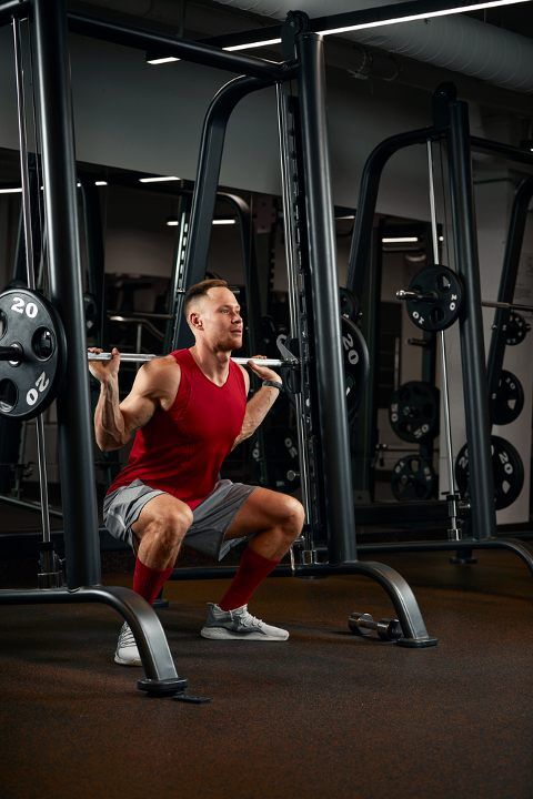 Man doing smith machine squats at the gym