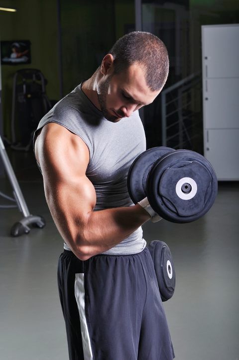 Man standing doing biceps curls