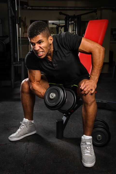 Man doing concentration curls on bench