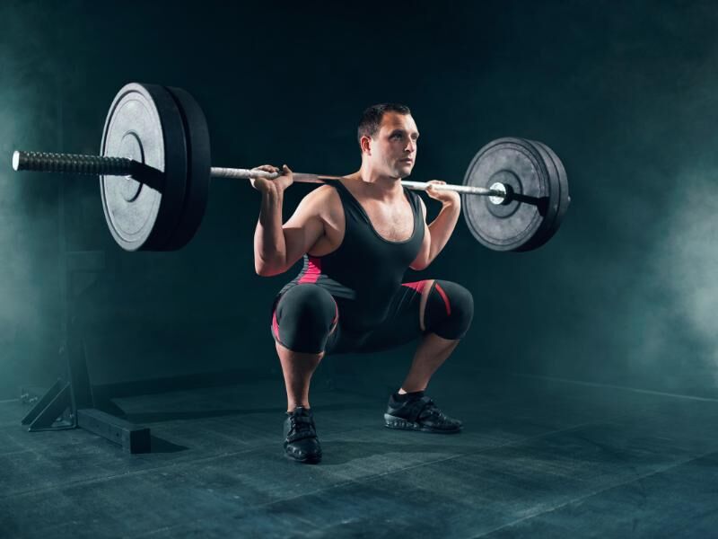 man performing barbell squats